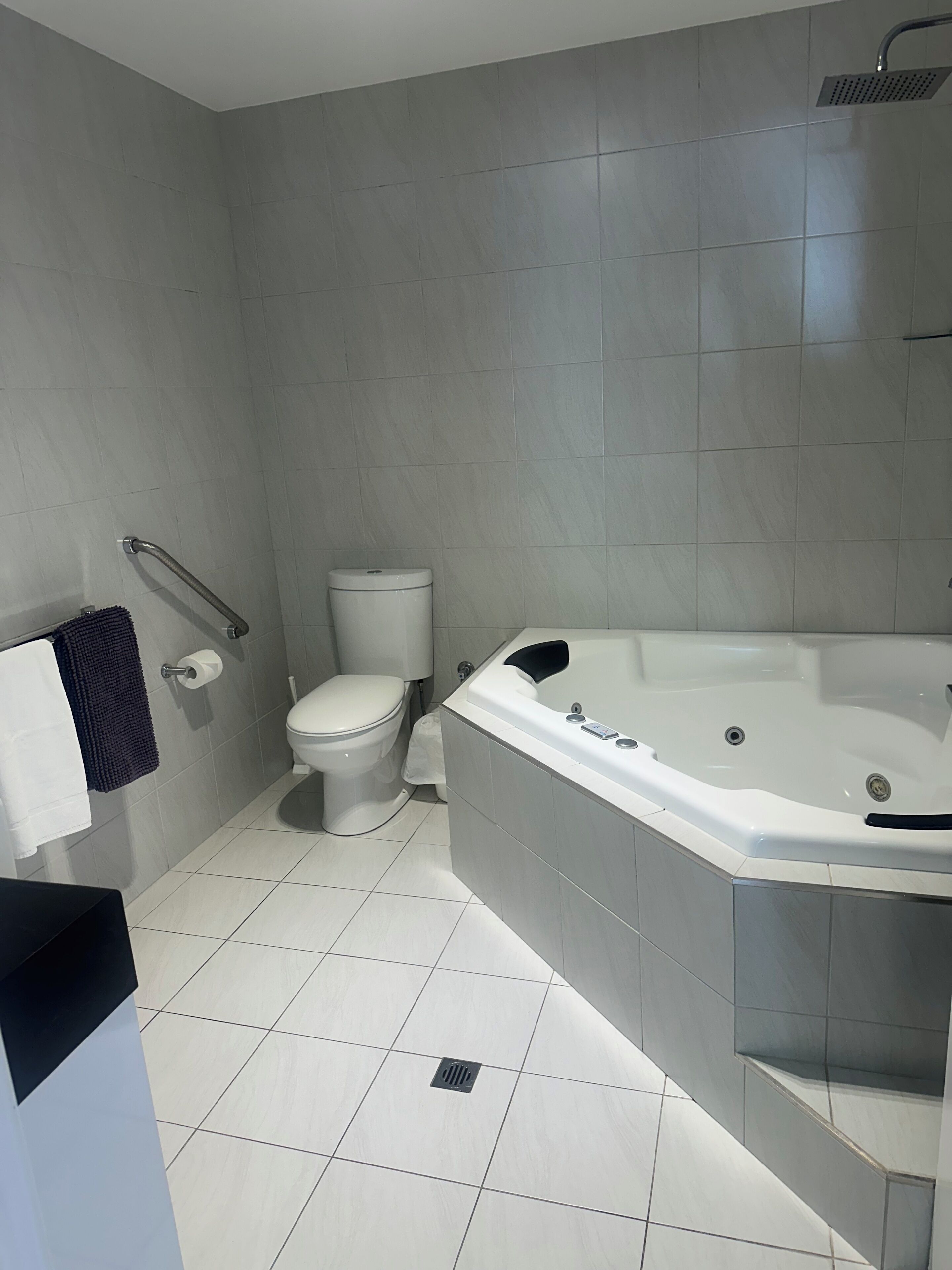 A modern bathroom with a toilet, a bathtub, and a shower.