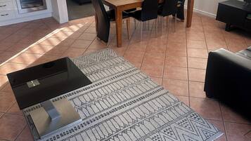 Una sala de estar moderna con comedor, una cocina con horno y televisión.