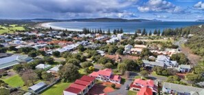 An aerial view of a coastal residential area with houses, roads, and a beach. - Pelicans Albany (Middleton Beach)