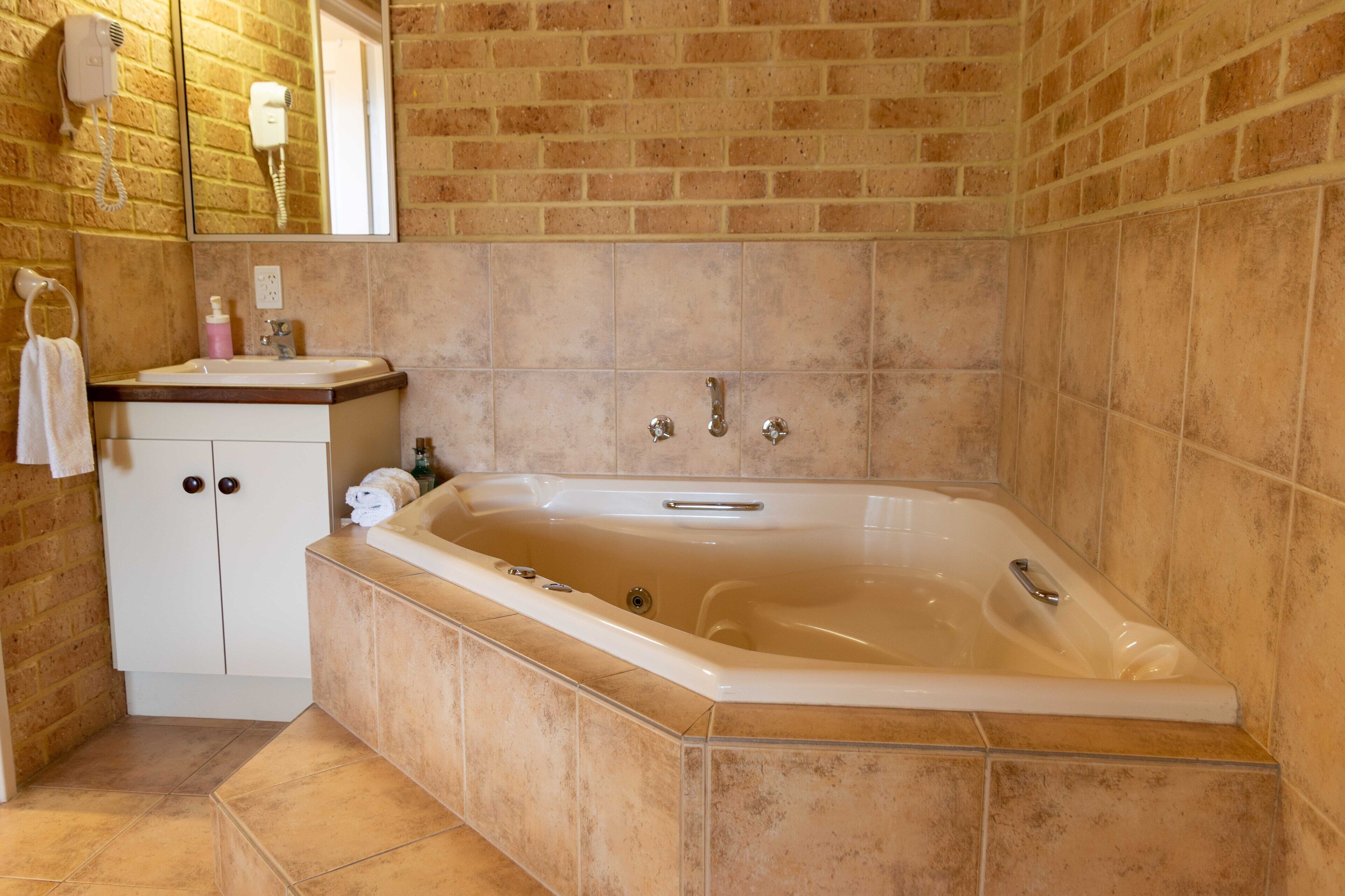 Un baño con una bañera, un lavabo y un espejo.