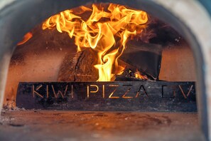 A wood-fired oven with the text "KIWI PIZZA OV" visible on the front. - Tasman Holiday Parks - Picton (Picton)