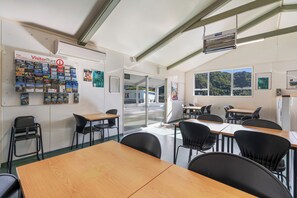 A visitor center with informational brochures, a reception desk, and a view of the outdoors through large windows. - Tasman Holiday Parks - Picton (Picton)