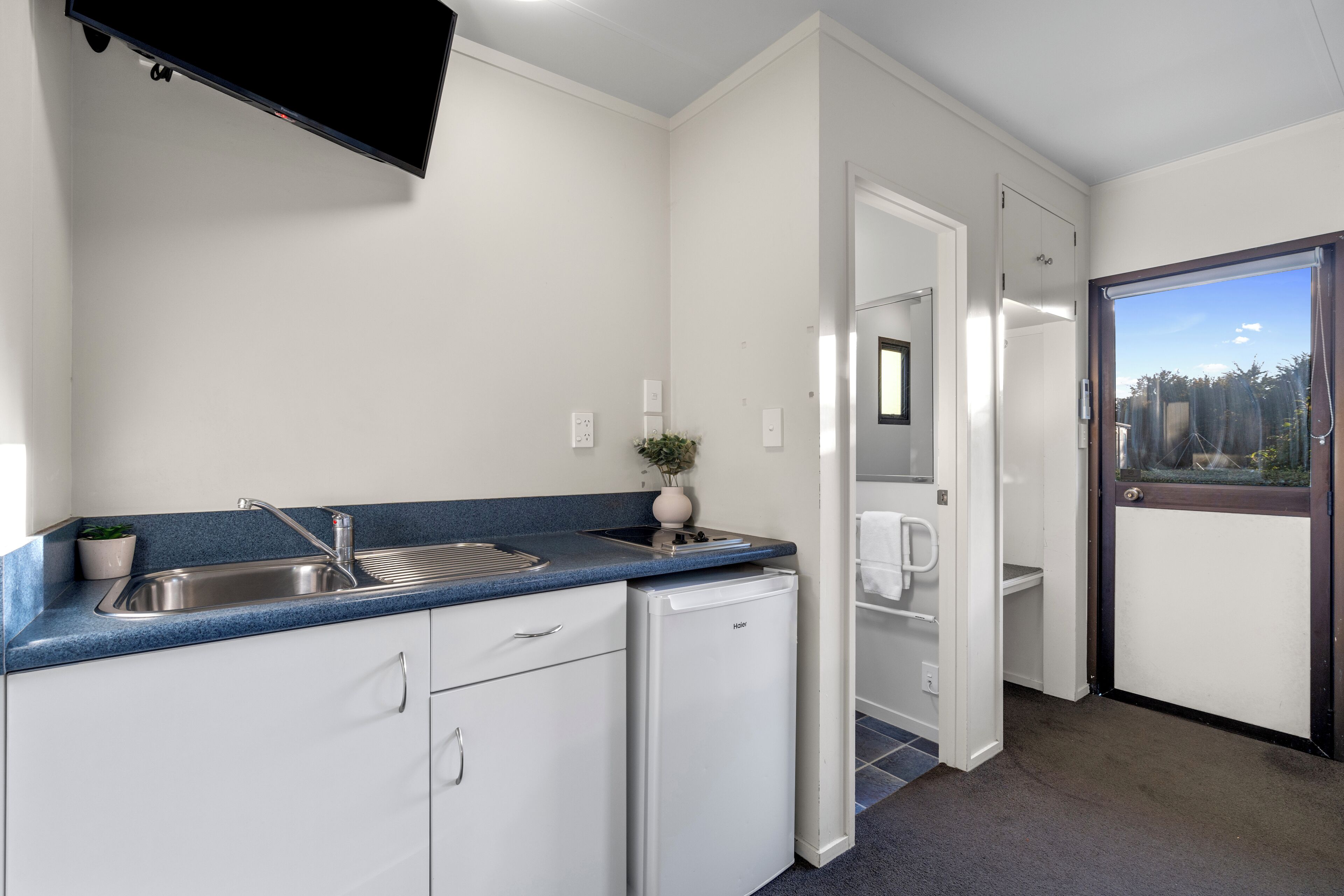 A compact kitchen with a built-in dishwasher, a sink, and a small countertop.