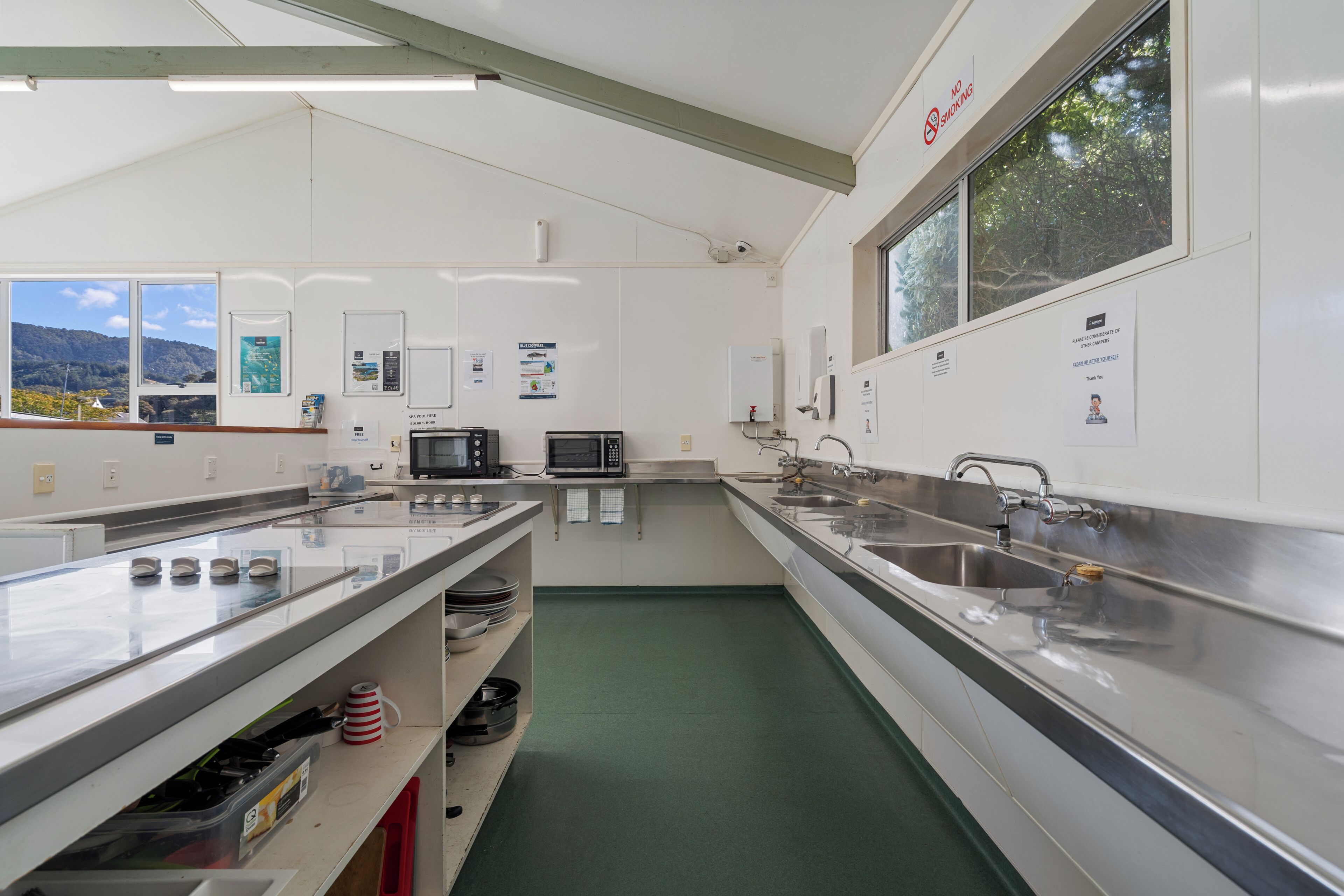Una cucina moderna con elettrodomestici in acciaio inossidabile, un lavandino grande e vista sull'esterno.