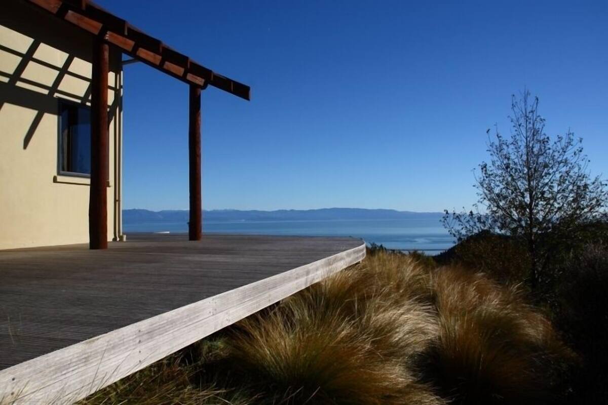 Una terraza de madera que conduce a un edificio con vista al océano.