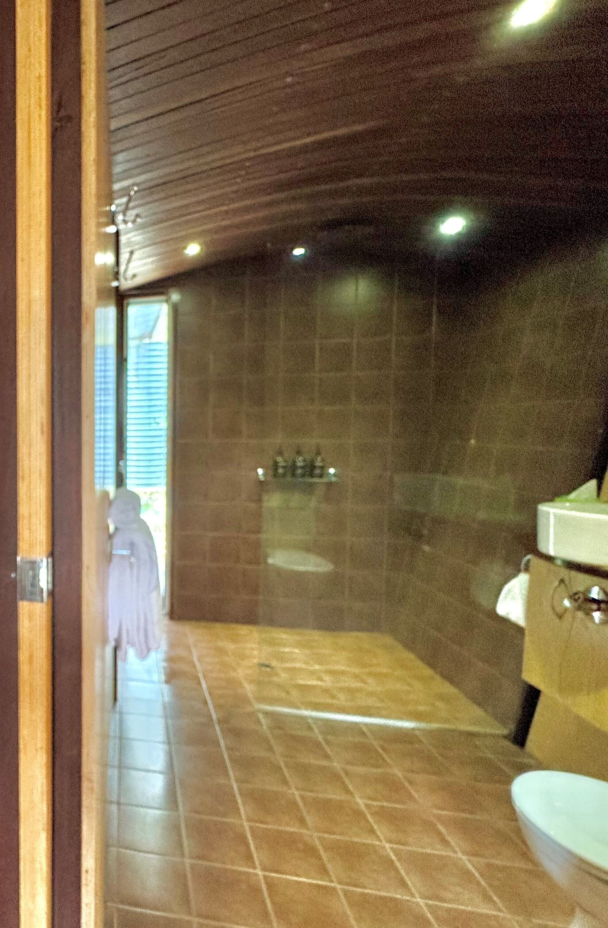 Un baño con ducha, lavabo e inodoro.