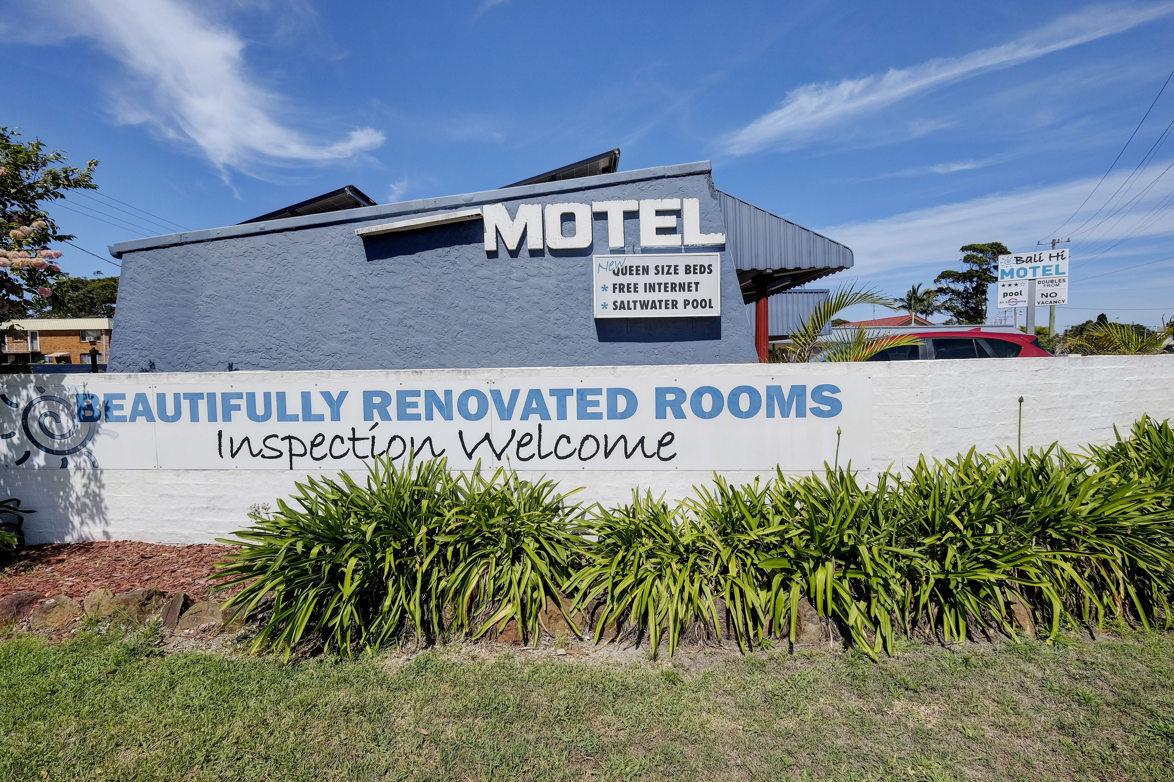 A motel sign with amenities like queen size beds, free internet, and a saltwater pool.