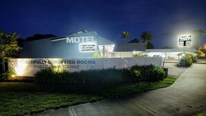Un motel amb un cartell que diu "Llits Queen Size, Internet gratuït, Piscina d'aigua salada" i "Habitacions rebedores, visites benvingudes".