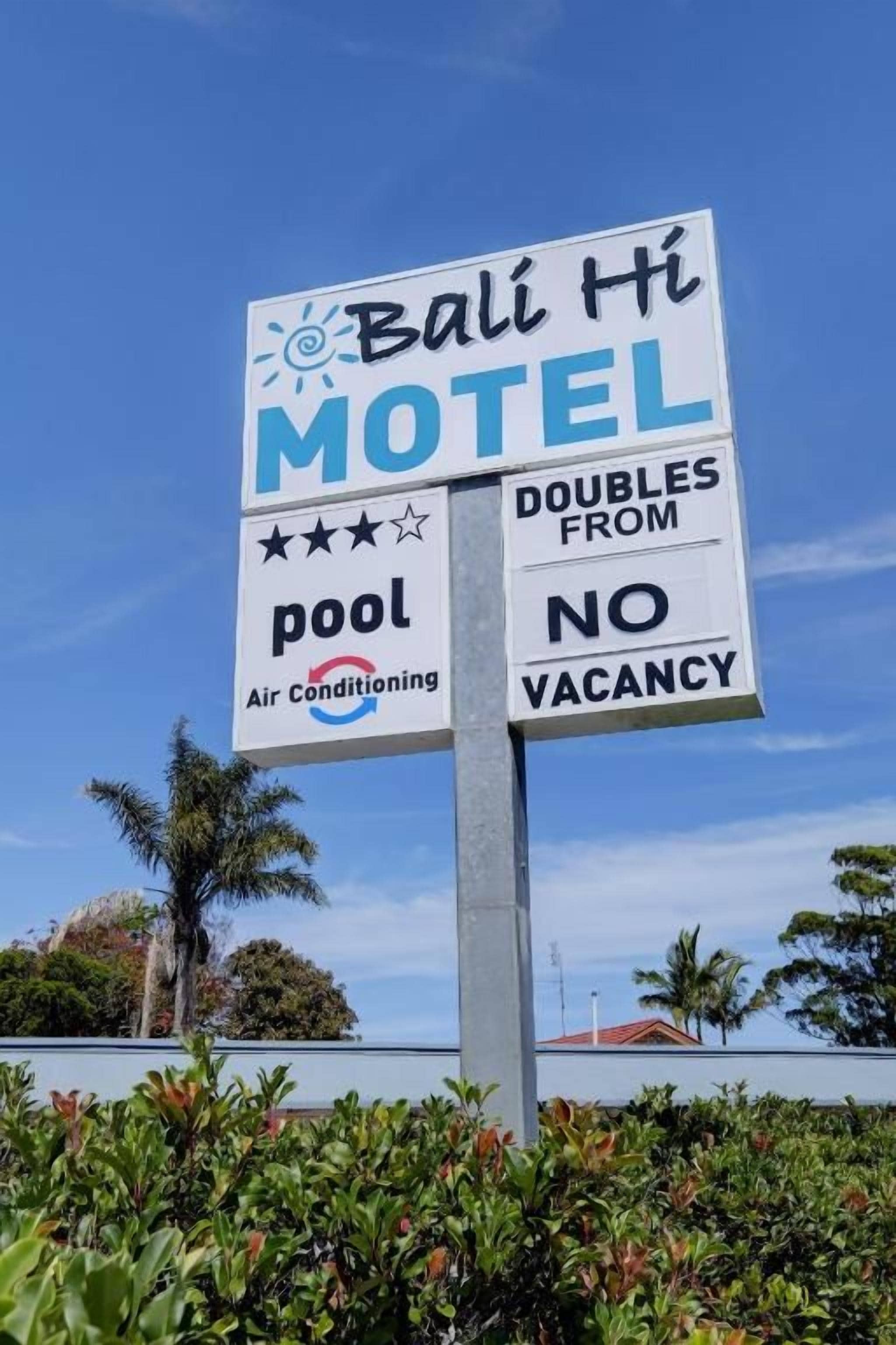Letrero del motel Bali Hi que anuncia piscina y aire acondicionado, con una habitación doble disponible.