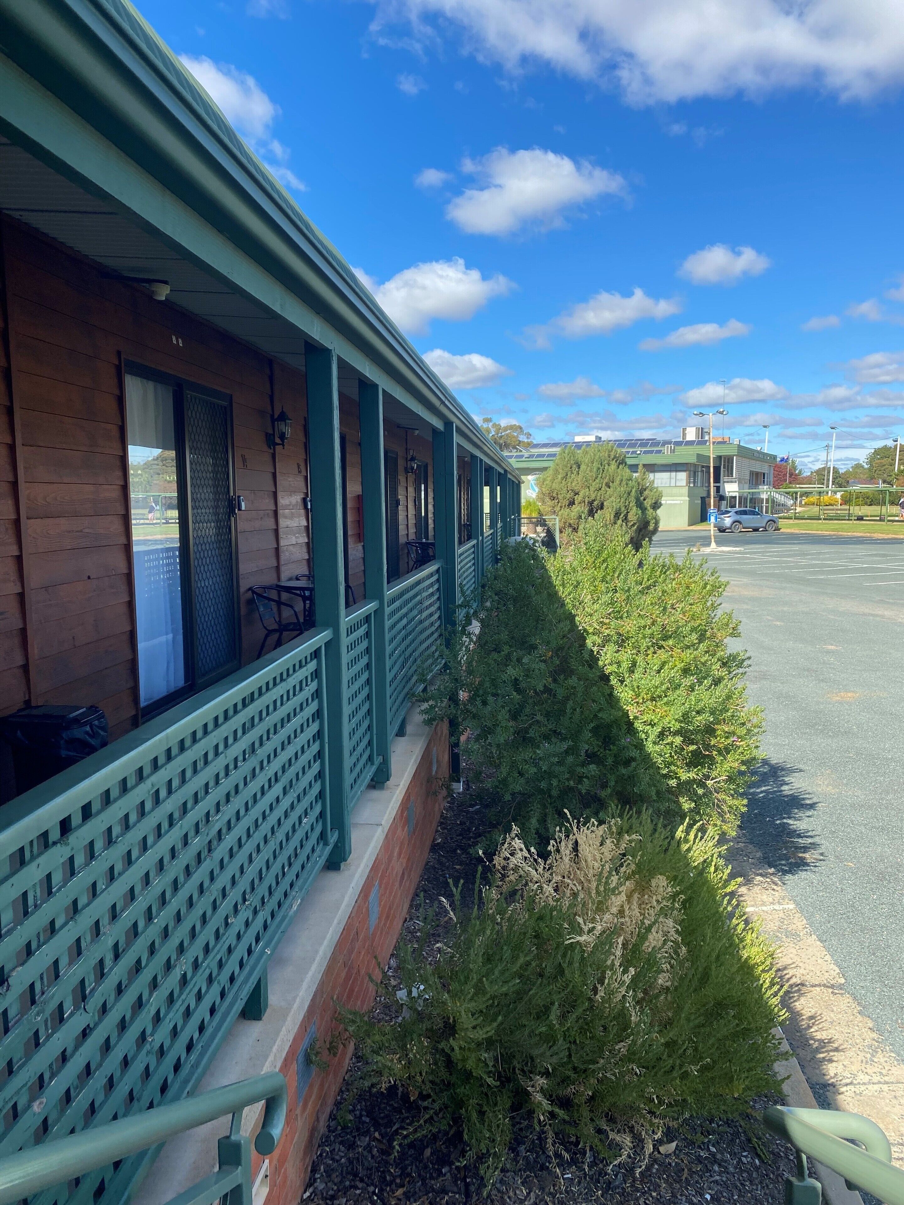 A building with a covered porch and a parking lot.
