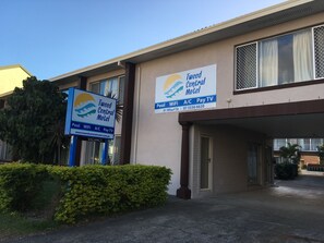 A building with a sign for Tweed Central Motel, indicating amenities like pool, WiFi, A/C, and Pay TV. - Tweed Central Motel (Tweed Heads)