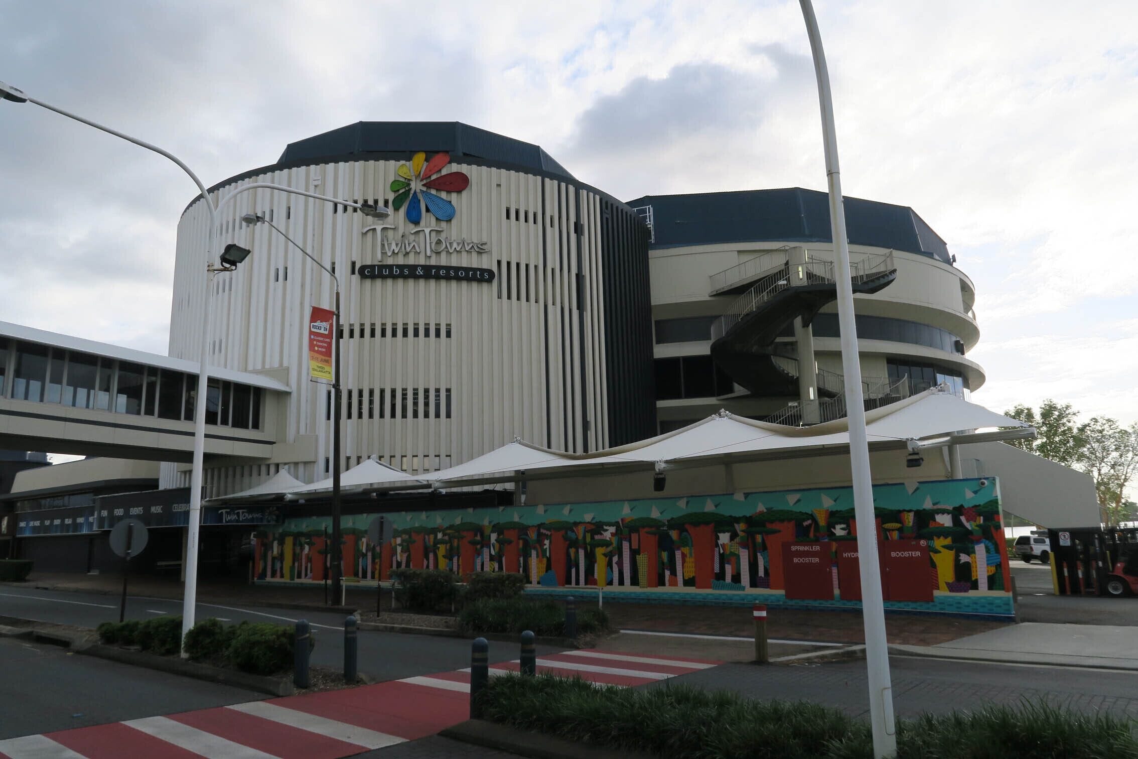 Un hôtel moderne doté d’une façade à rayures originales et d’un logo coloré.