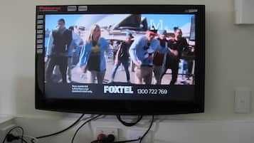 Un televisor mostrando un programa de noticias con un número de contacto visible para Foxtel.
