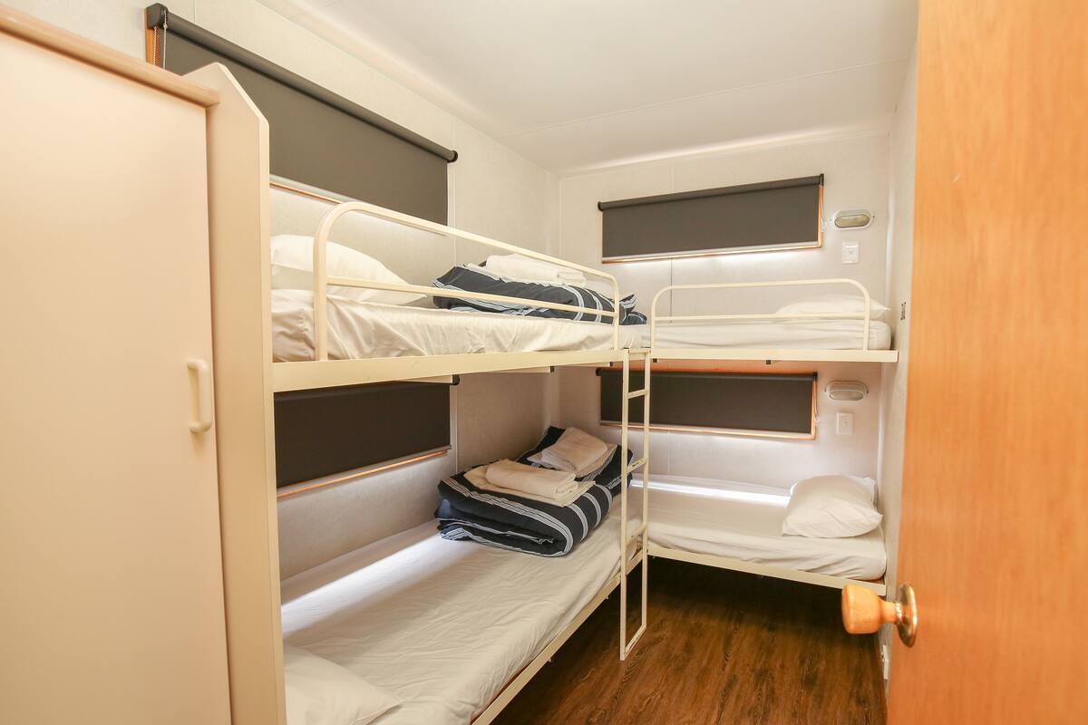 A bunk bed room with a wooden door and a small window.