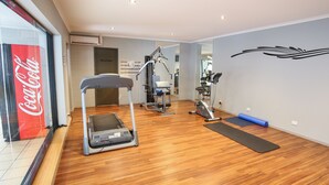 Ein Fitnessraum mit Laufband, Ergometer und Gewichten.