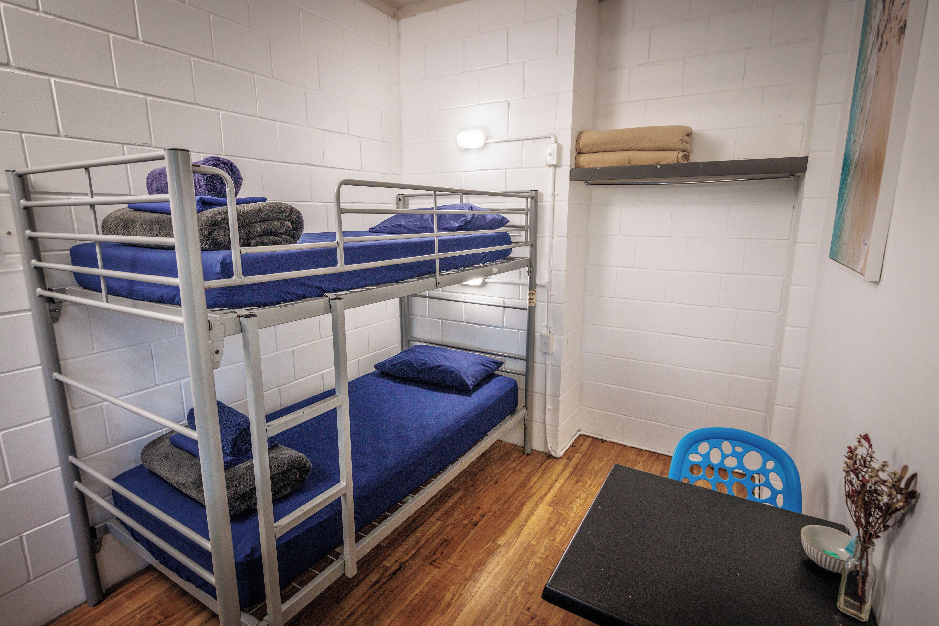 A bunk bed room with a table and a chair.