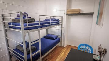 A bunk bed room with a table and a chair.