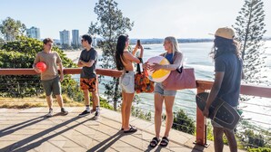 A group of people standing on a balcony overlooking a body of water with buildings in the background. - YHA Coolangatta Gold Coast (Bilinga)