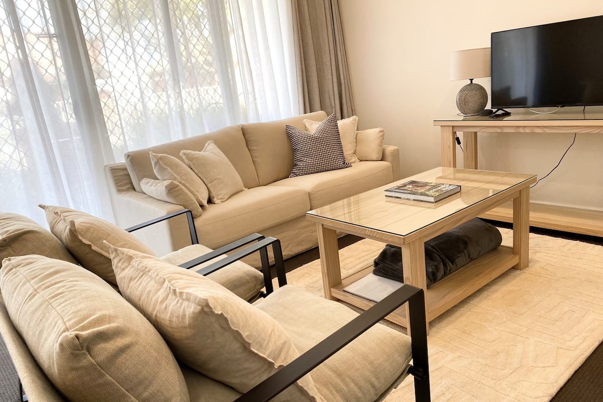 A modern living room with a sofa, coffee table, and TV.