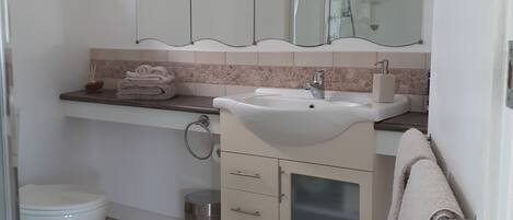 Un baño moderno con inodoro, lavabo y espejo.