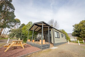 A single-story mobile home with a covered porch, a picnic table, and potted plants. - BIG4 Breeze Holiday Parks - Eildon (Eildon)