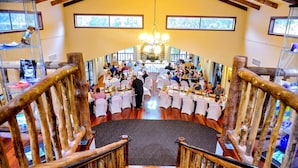 A spacious hall with a high ceiling, wooden railings, and a central chandelier. Tables are set with white tablecloths and chairs. - Evedon Park Bush Retreat (Burekup)