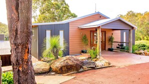 A modern house with a large rock garden, a tree, and a well-maintained lawn. - Evedon Park Bush Retreat (Burekup)