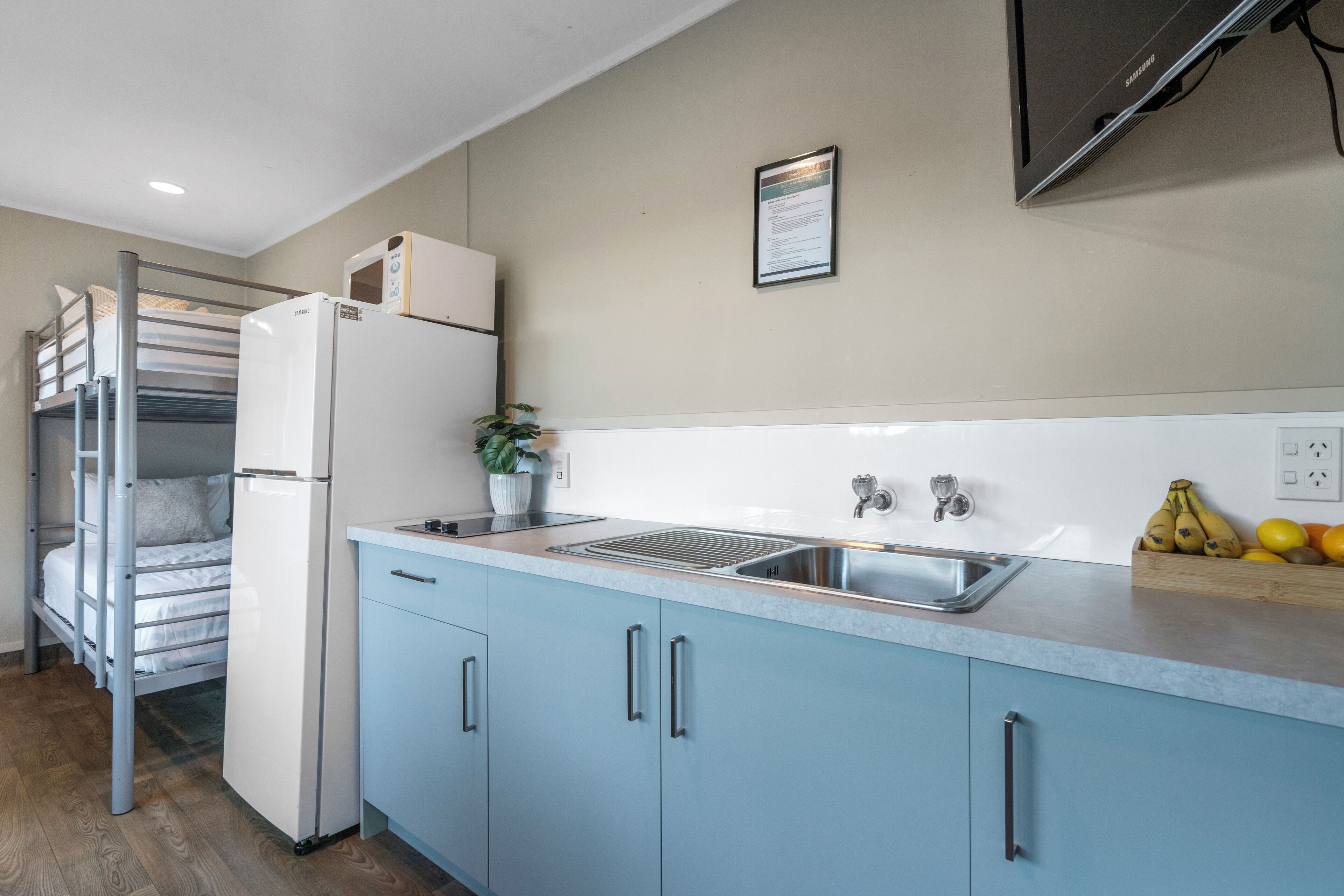 A compact kitchen with a built-in refrigerator, a sink, and a small countertop.
