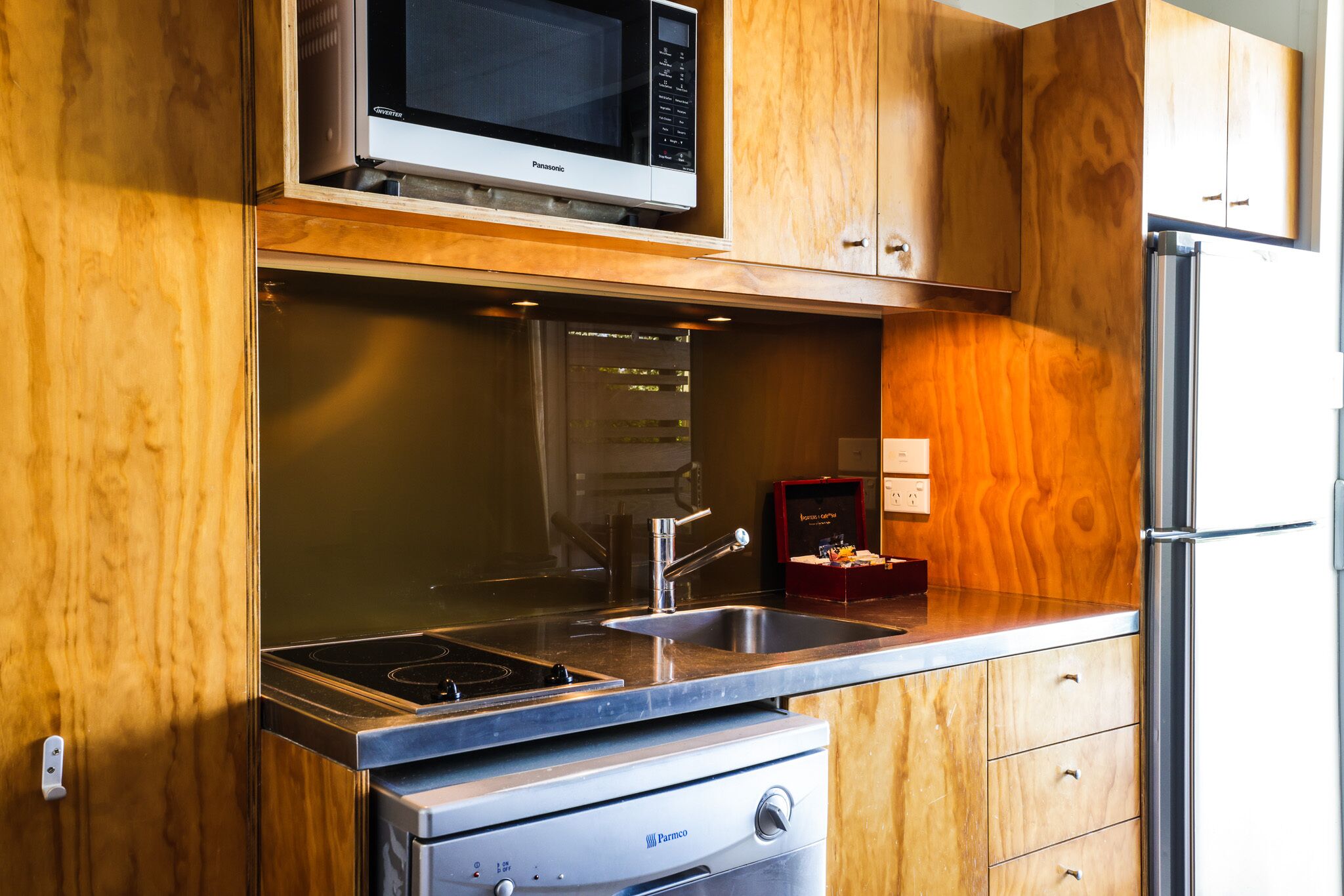 A kitchen with a microwave, stove, sink, and refrigerator.