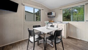 Una cocina funcional con microondas, una mesa de comedor con sillas y un ventanal grande.