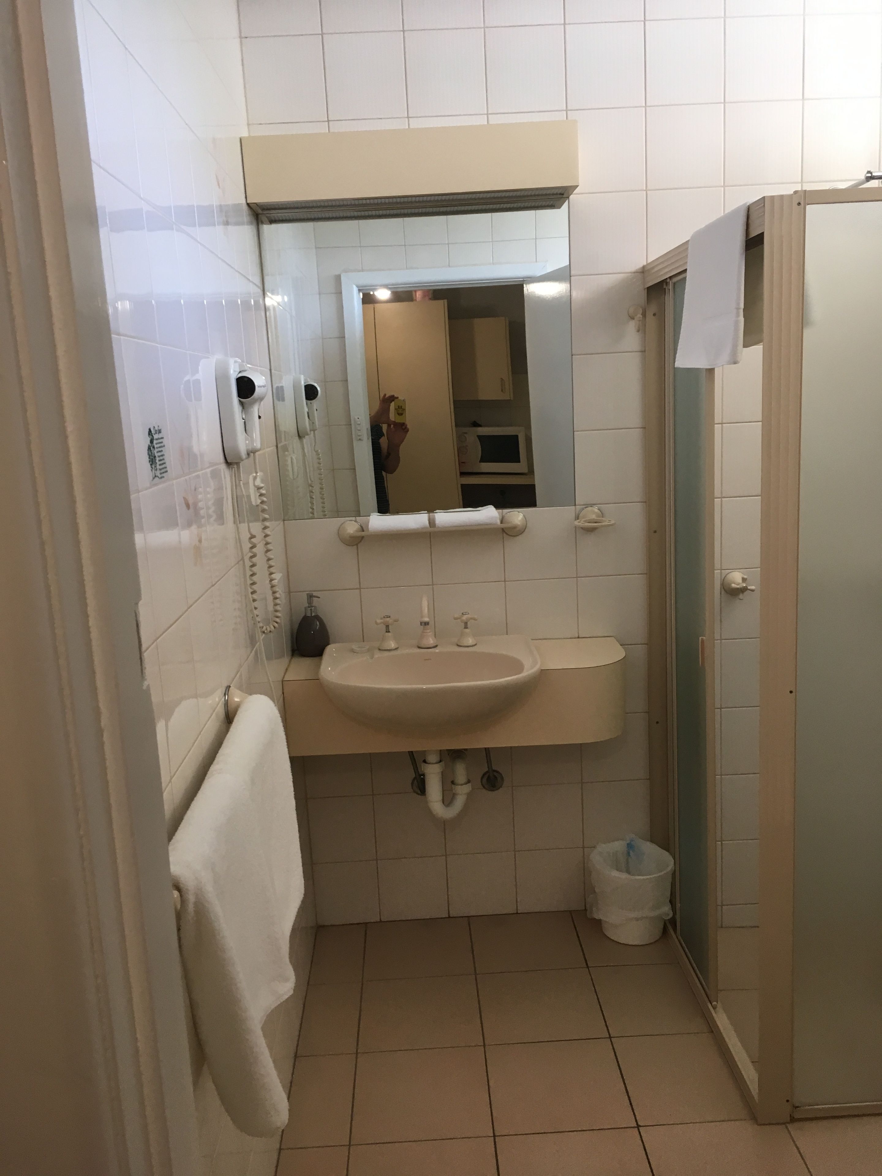 A bathroom with a sink, mirror, and a towel rack.