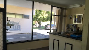 Ein Zimmer mit großem Fenster, einer Rezeption und Blick auf die Straße.