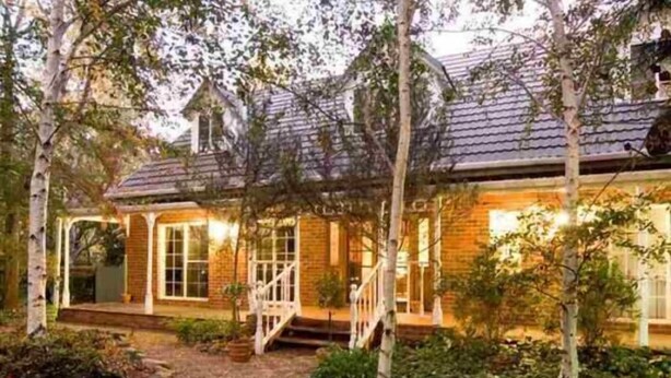 A two-story house with a brick exterior, a covered porch, and a gravel pathway leading to the entrance. - Chalets Lumineux (Bright)