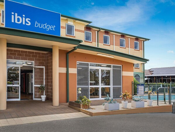 A two-story building with a sign reading "ibis budget." - Coffs Harbour Budget Stay (Coffs Harbour)