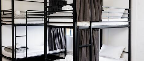 Habitación con literas, dos camas, cada una con colchón y almohadas.