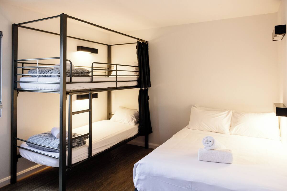 A bunk bed room with a single bed on the right.