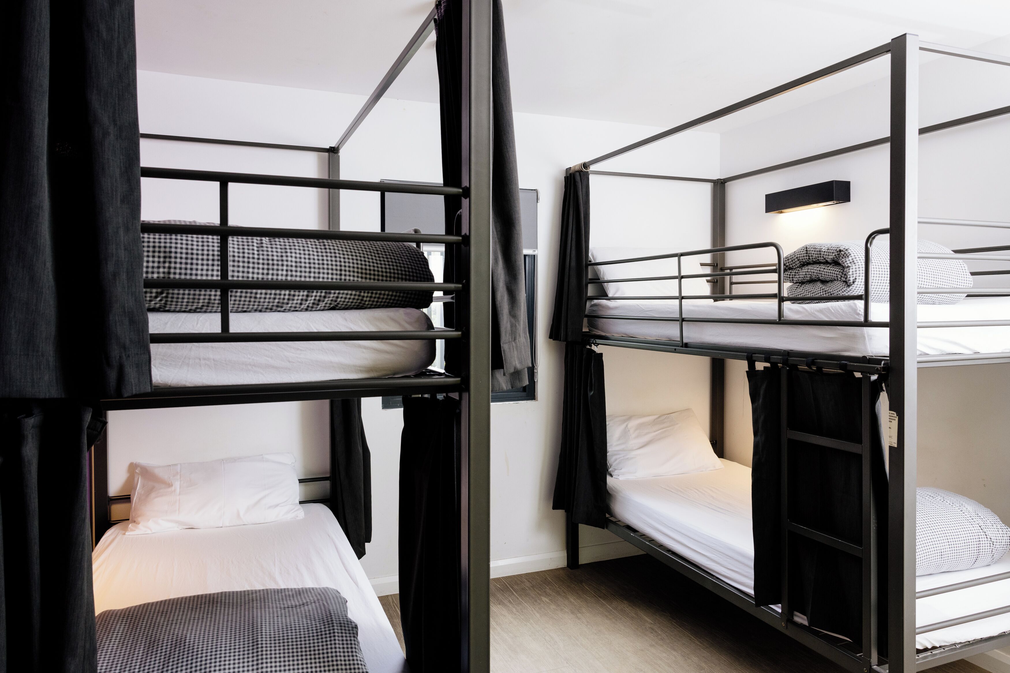 A bunk bed room with a flat-screen TV mounted on the wall.