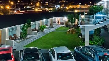 Enjoy the serene atmosphere of this residential building with a beautifully maintained lawn and outdoor seating area.
