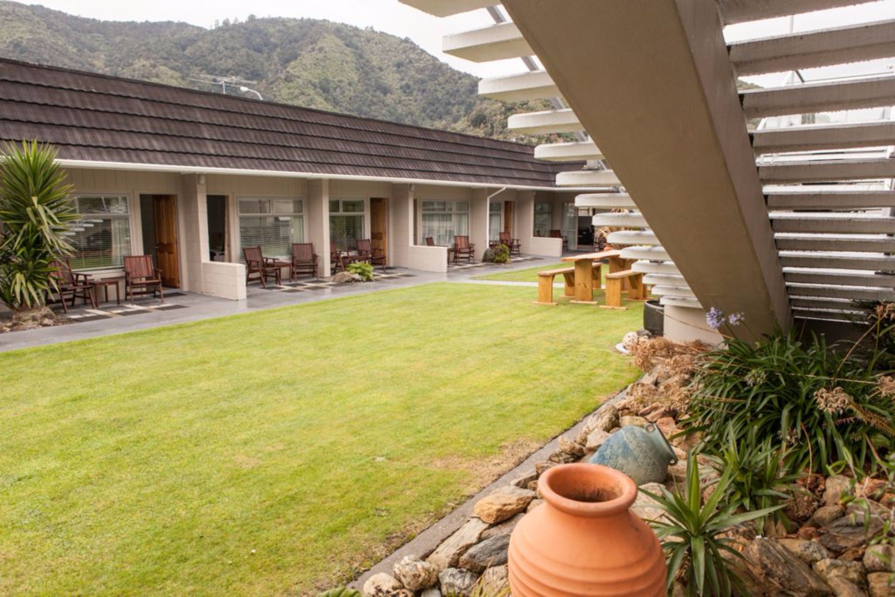 A modern building with a flat roof, large windows, and a well-maintained lawn.