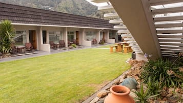 A modern building with a flat roof, large windows, and a well-maintained lawn.