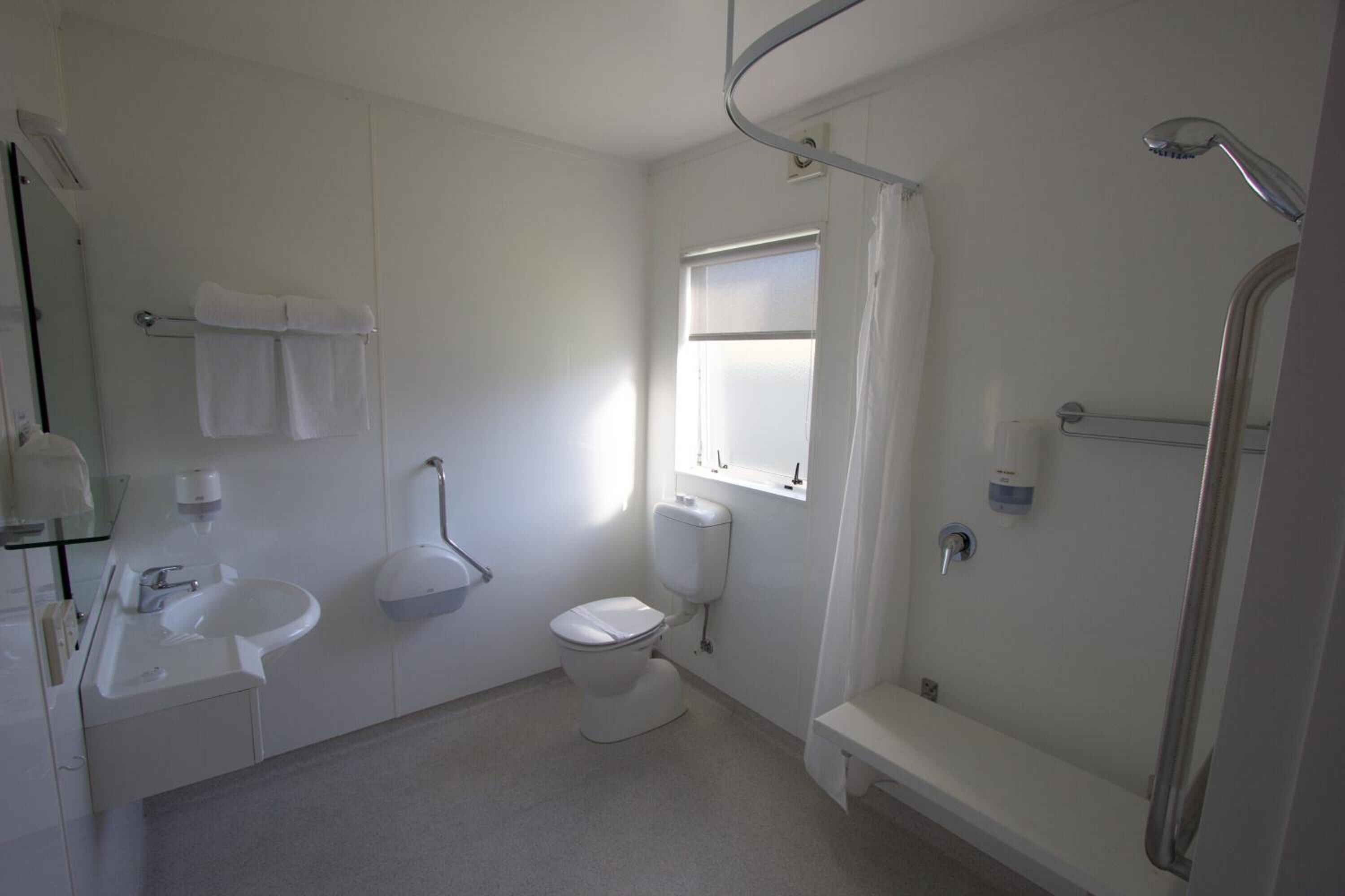 A modern bathroom with a toilet, sink, and shower area.