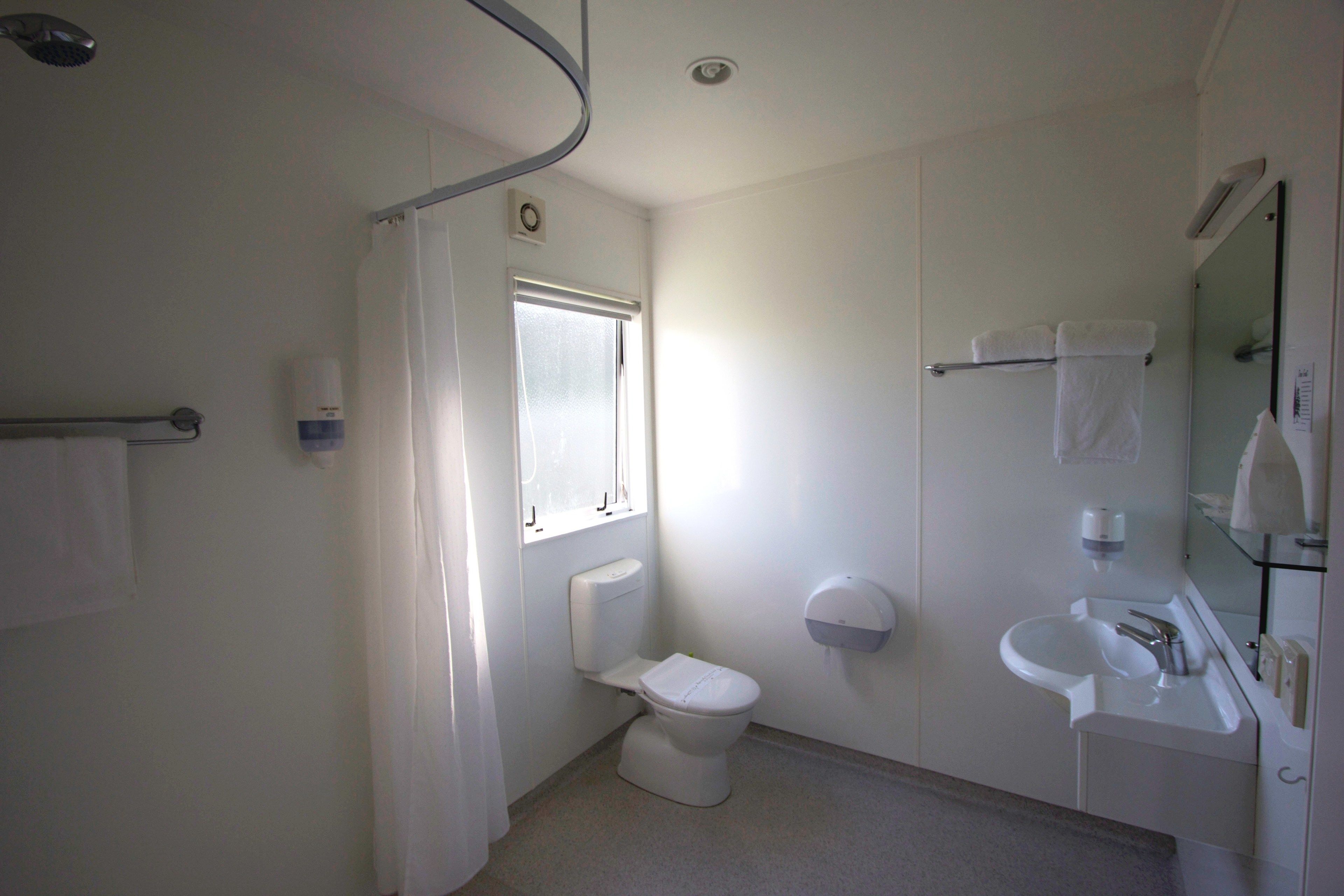 Un bagno piccolo e pulito con WC, lavandino e doccia.