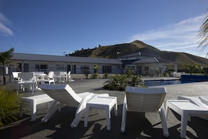 Relax by the pool amidst a serene hilly landscape.