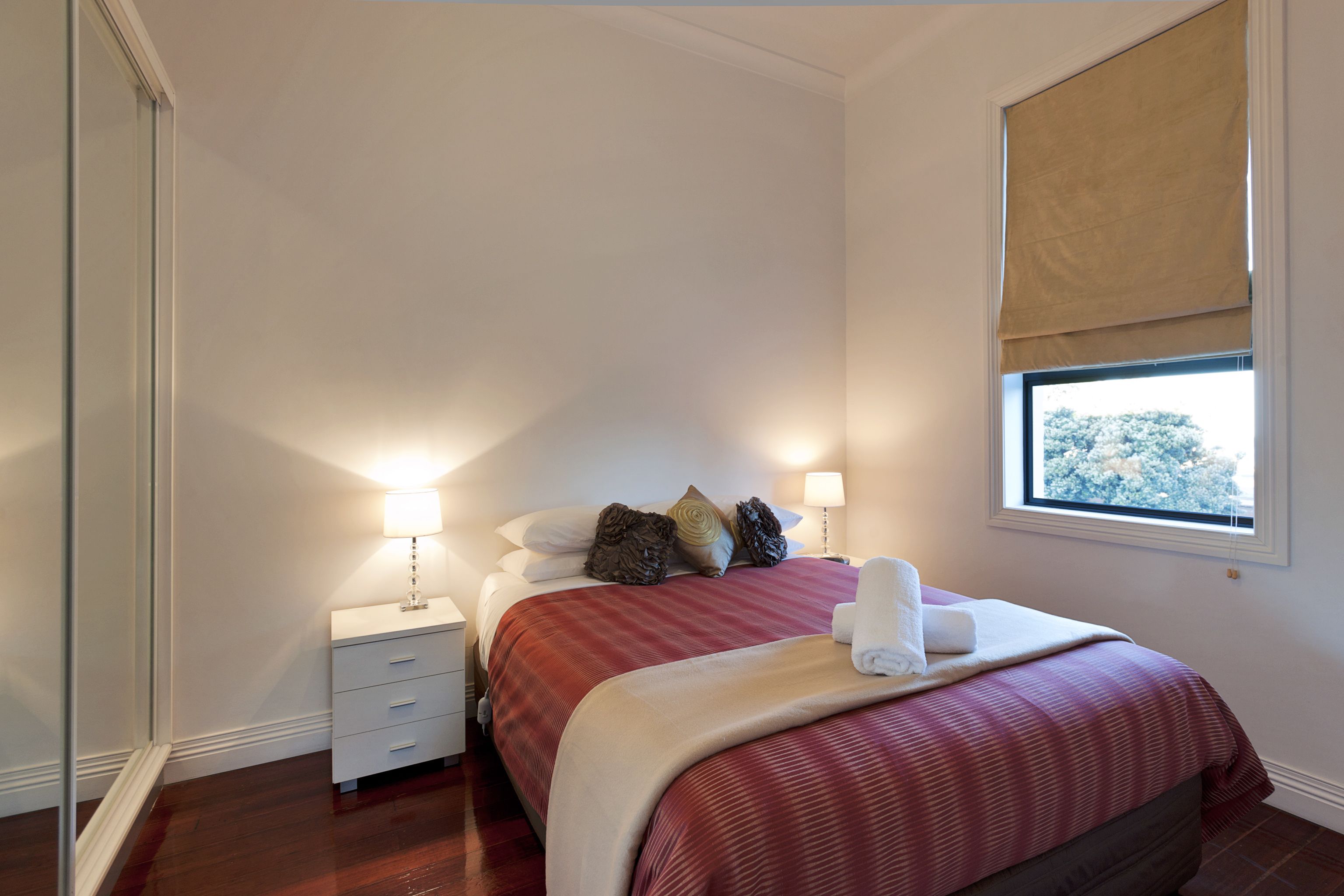 Un dormitorio con cama, mesitas de noche y ventana con vistas.