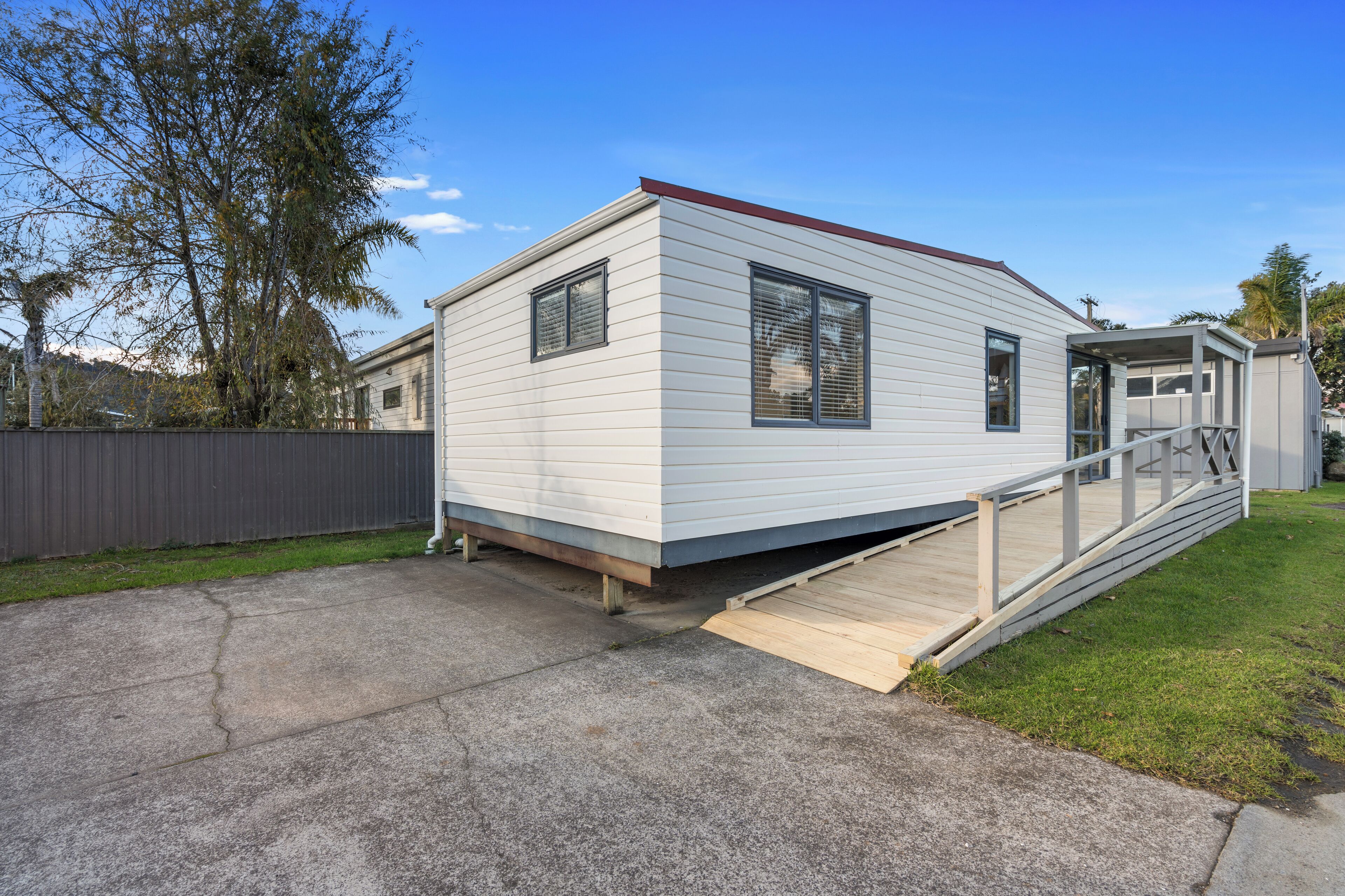 A single-story mobile home with a front deck and a small porch.