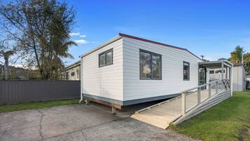 A single-story mobile home with a front deck and a small porch.