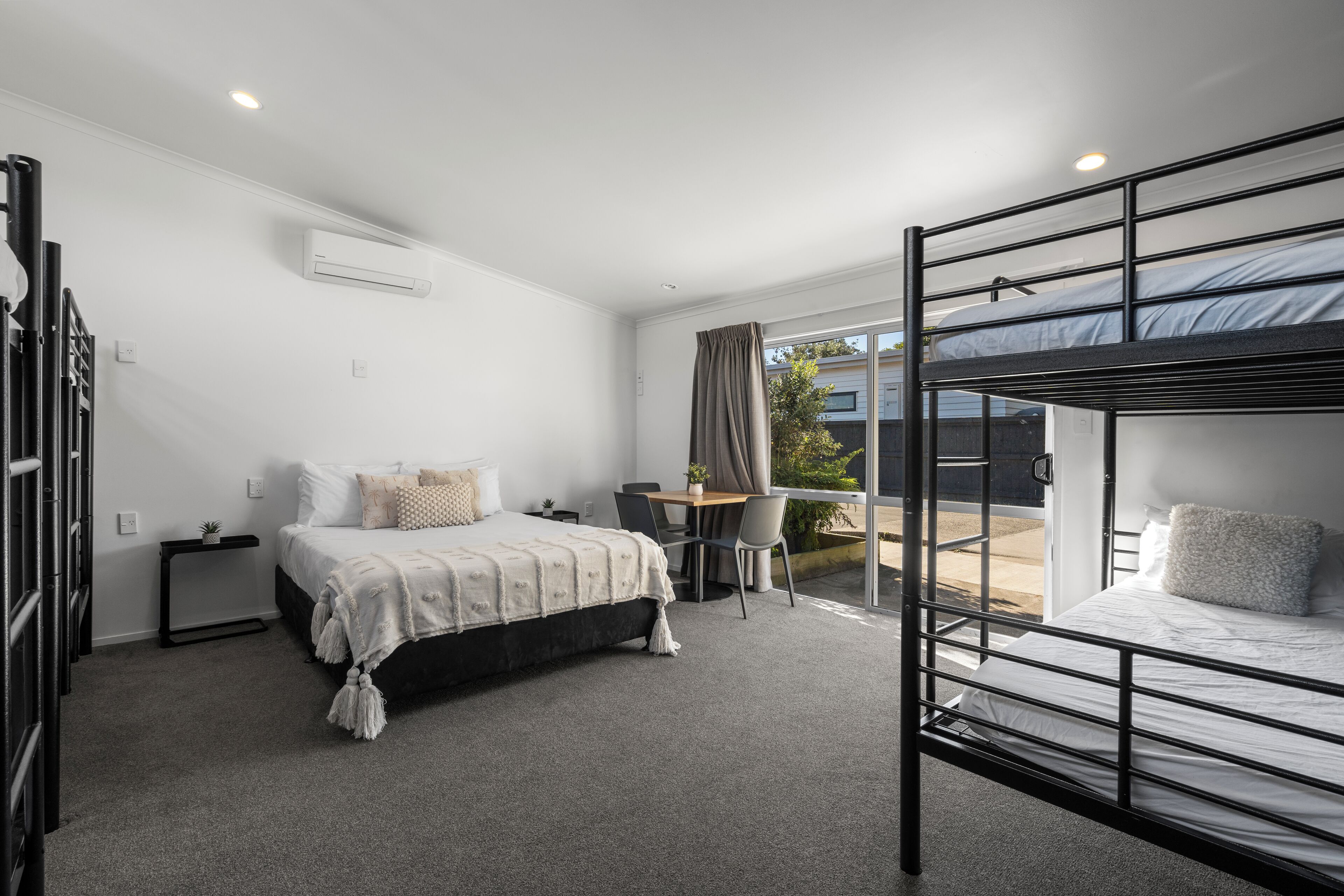 A modern bedroom with a bunk bed, a desk, and a chair.