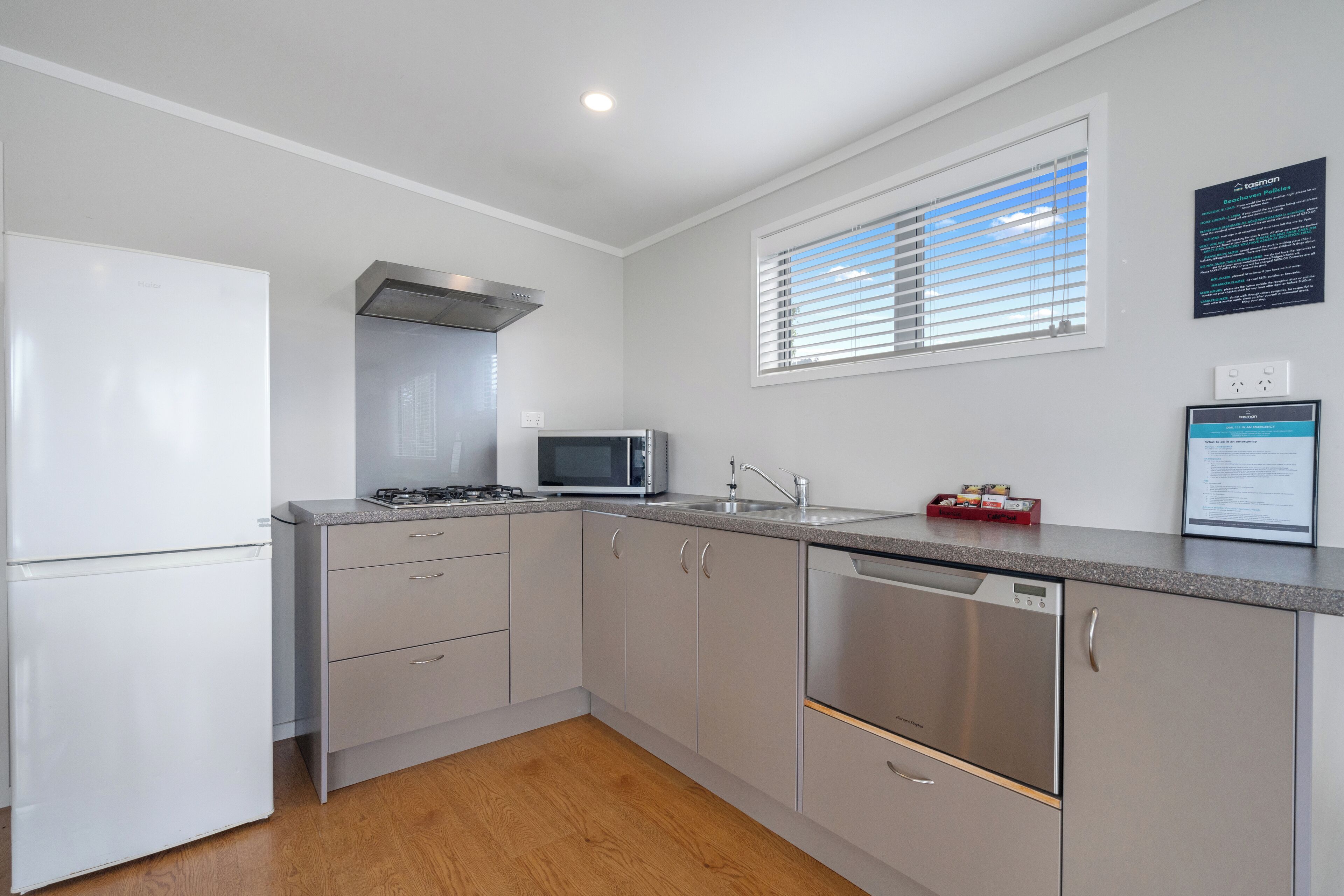 A modern kitchen with a refrigerator, microwave, stove, sink, and dishwasher.