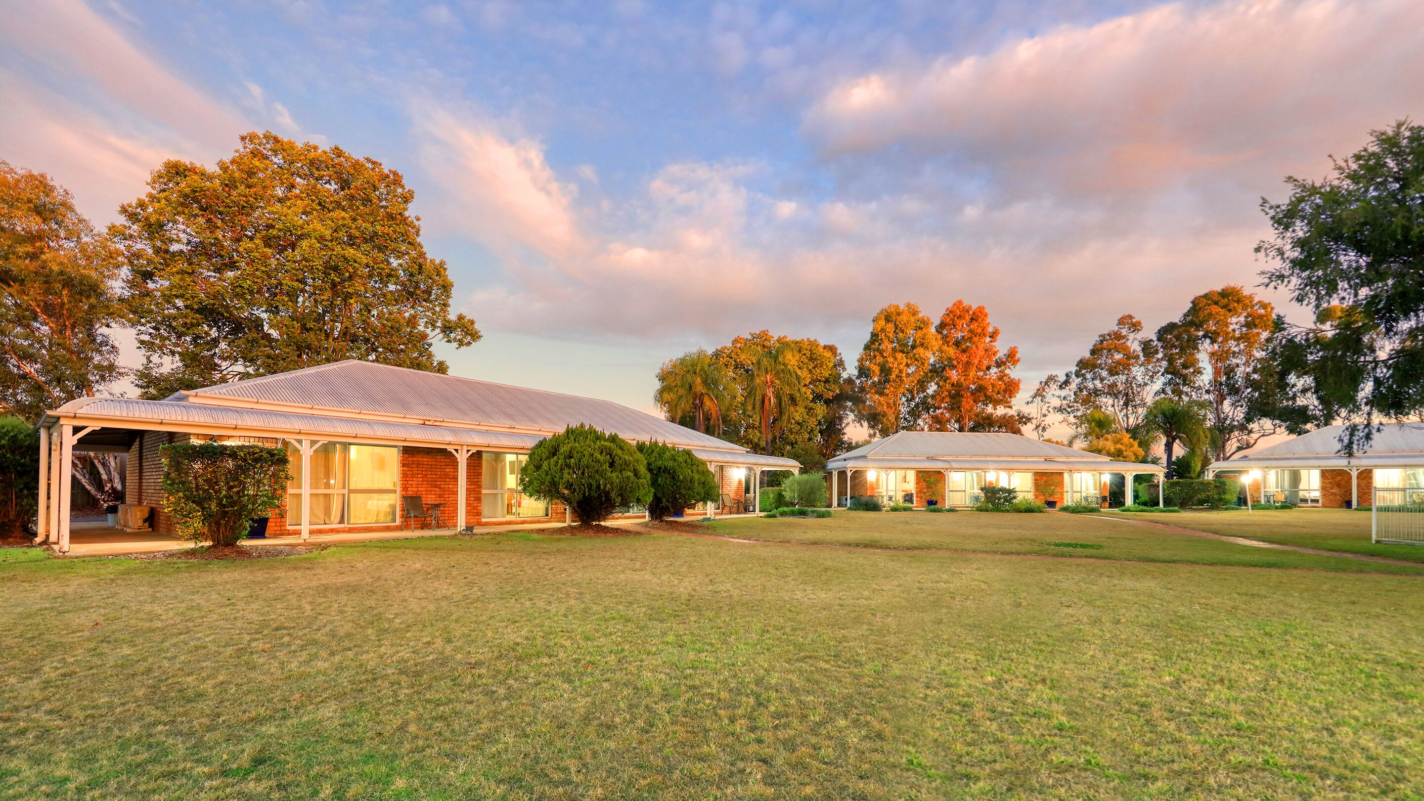 A residential area with multiple houses, each featuring a covered porch and a brick facade.