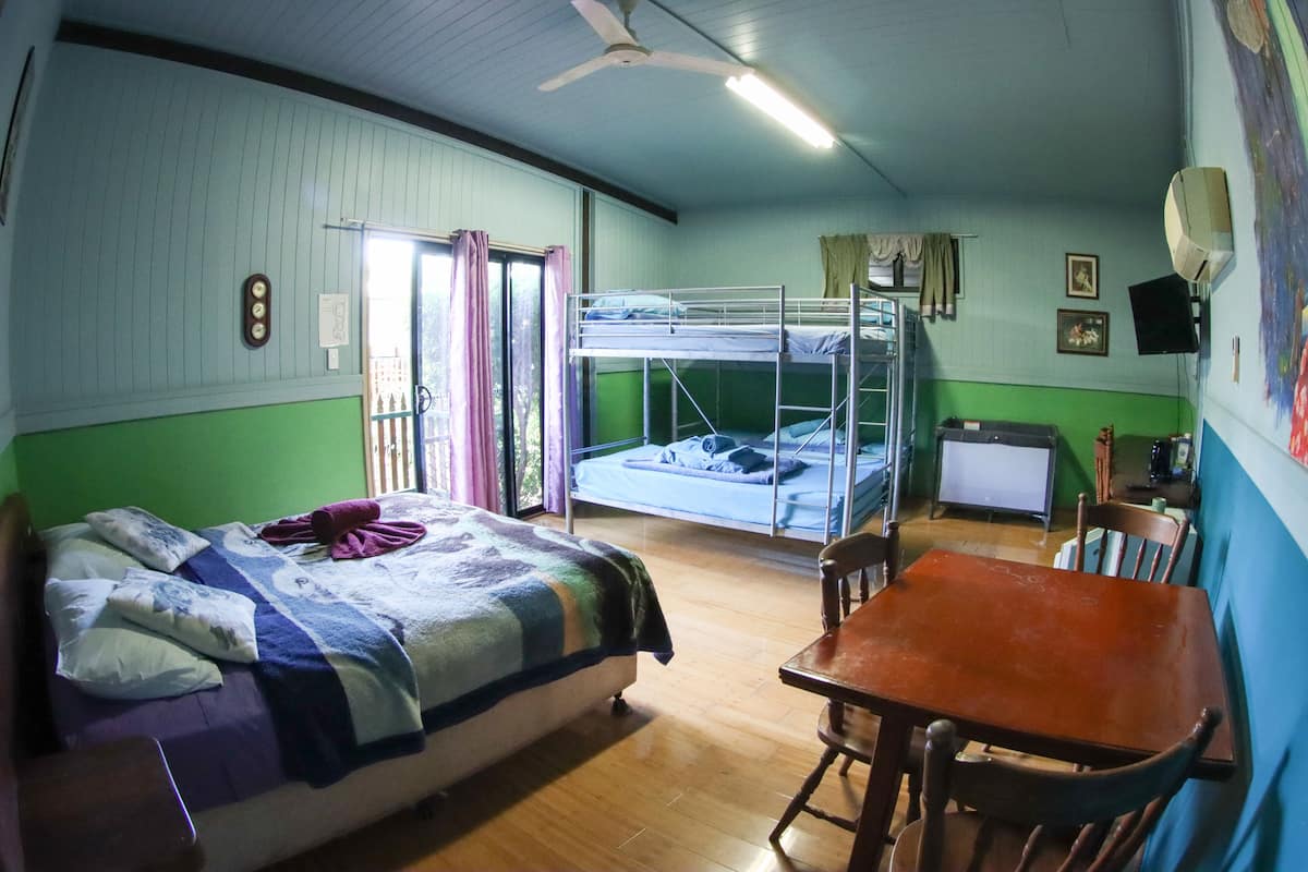 A room with bunk beds, a wooden table, and a television.